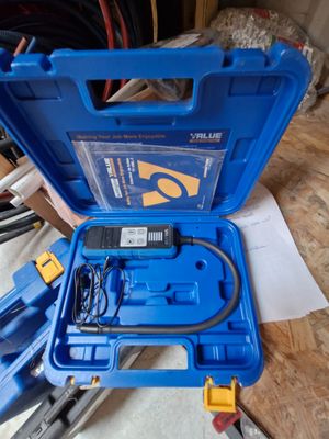 une image représentant une boîte à outils bleue posée sur un plancher en bois