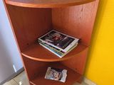 une étagère d'angle sur laquelle sont posés des magazines