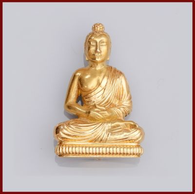 une statue en or représentant un Bouddha assis sur une table