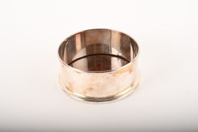 une bague en argent posée sur une surface blanche