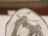 a clear glass vase with a pair of scissors inside of it