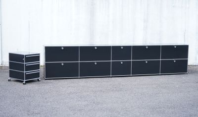 a black cabinet with drawers and a white wall in the background