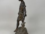 bronze statue of a boy with a dog on a pedestal