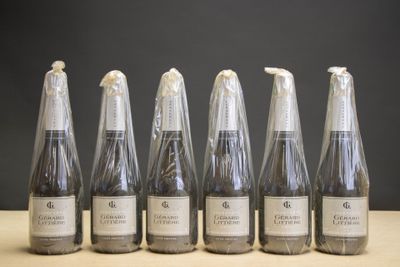 six bouteilles de vin sont alignées sur une table