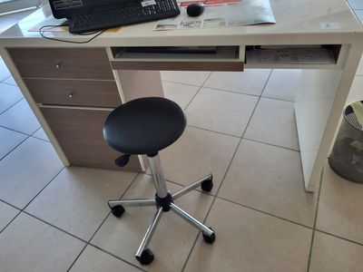 a computer desk with a chair and a laptop on it