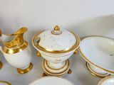 beaucoup d'assiettes et de tasses blanches et dorées