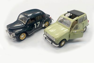 two toy cars sitting next to each other on a white surface