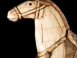 a wooden horse that is standing on a black surface