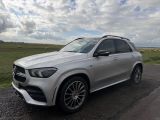 a silver mercedes suv parked on the side of a road