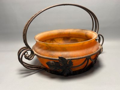 a small orange bowl with a handle on a table