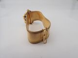 an image of a close up of a gold bracelet on a white surface
