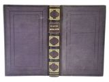 un livre violet aux bords dorés et à la couverture noire