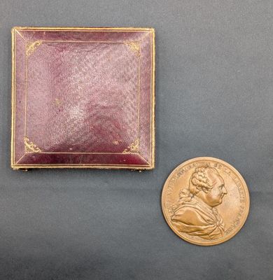 une image représentant une petite médaille en or et une petite pièce en or