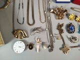 a lot of jewelry on a table with a clock