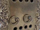 a metal clock with holes in the middle of it