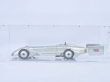 a silver toy car in a clear box on a white surface