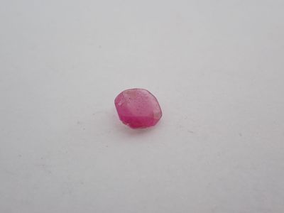 une pierre rose posée sur une surface blanche