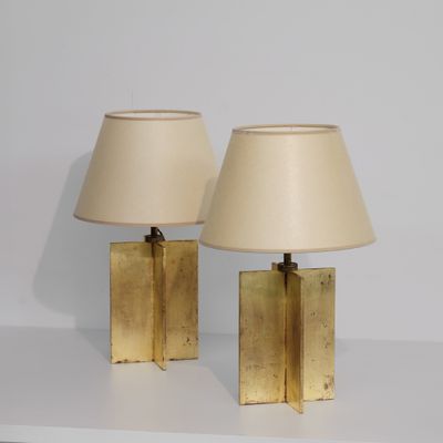 une paire de lampes de table en laiton avec des abat-jours, posées sur une table blanche
