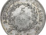 a silver coin with a wreath on the front of it