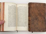 someone is holding an old book open to show the pages