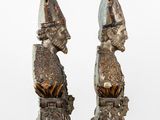 two statues of a man and a woman with hats on their heads