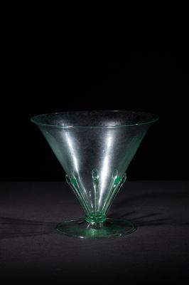 a green glass vase sitting on top of a table