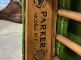 a wooden chair that has a green blanket on top of it