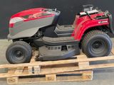 une tondeuse à gazon rouge posée sur une palette dans un entrepôt