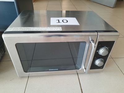 un micro-ondes posé par terre, avec une étiquette de prix dessus