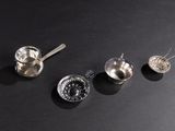 five spoons and a measuring spoon on a black surface