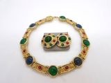 un gros plan d'un collier et d'une broche posés sur une surface blanche