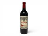 the bottle of red wine is sitting on a white surface