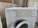 a washing machine that is sitting in the corner of a room