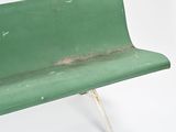 a green bench that is sitting on a white surface