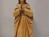 a statue of a man holding a rosary in his hands