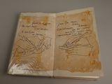 an old book with writing on it sitting on top of a table