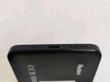 the back of a black cell phone with a white sticker on it