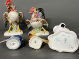 three figurines of roosters are sitting next to each other
