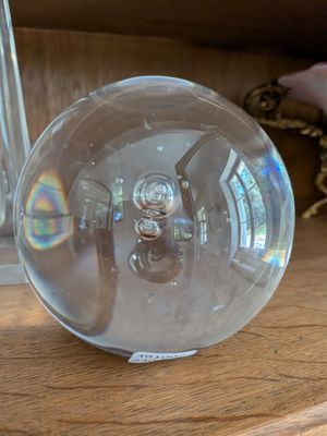 une boule de verre posée sur une étagère en bois