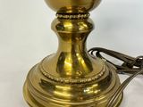 brass plated lamp with a cord plugged to the base