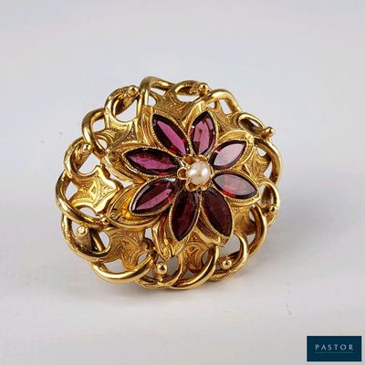 une image représentant une bague en or ornée d'un motif floral et d'une perle au centre