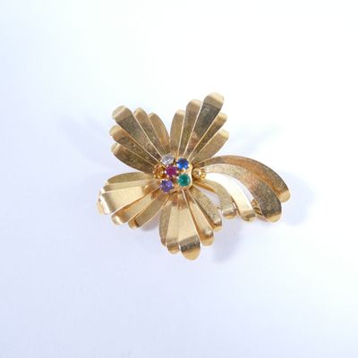 une broche en forme de fleur en or, ornée de pierres multicolores