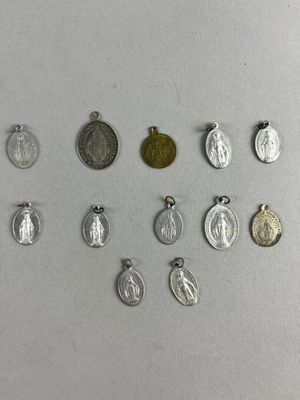 several different types of silver and gold charms on a white surface