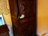 une armoire en bois placée dans un coin de la pièce, sur laquelle est posé un ordinateur