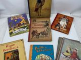 several children ' s books are sitting on a white surface