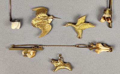a lot of gold brooches and pins on a table