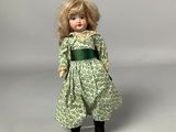 doll with blonde hair wearing a green dress and black boots