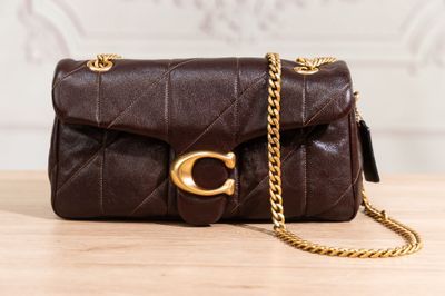 a close up of a brown purse on a wooden table