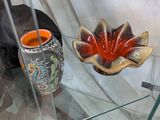 une table en verre sur laquelle se trouvent un vase et une bougie