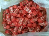 a plastic bag full of red soda bottles sitting on a table
